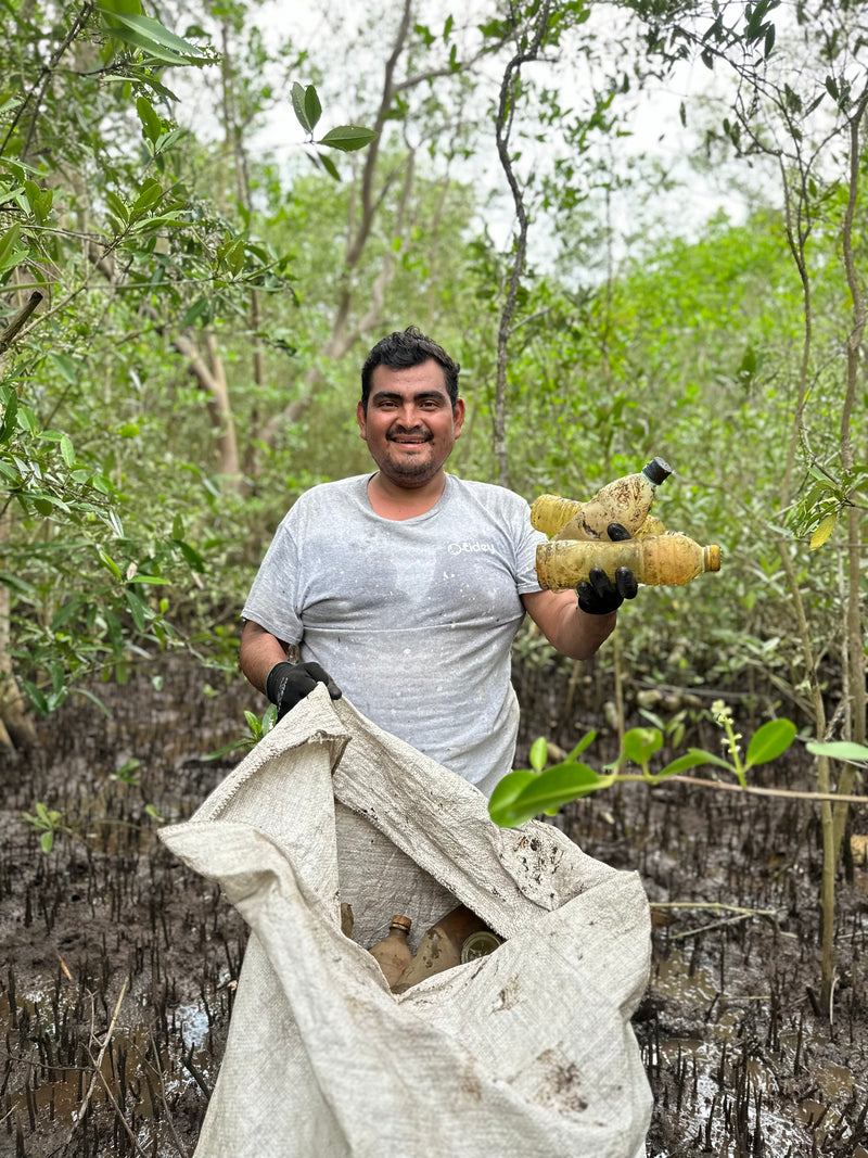 Man from Tidey Oceans picking up trash on the beach