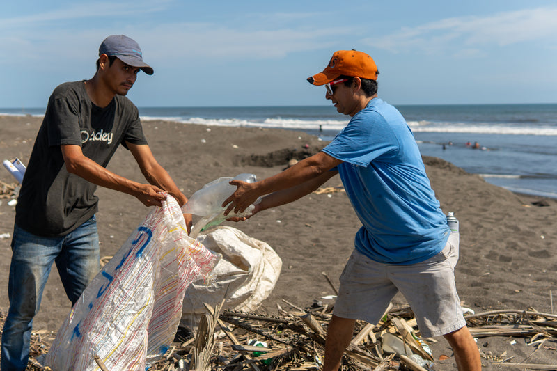 Man from Tidey Oceans picking up trash on the beach