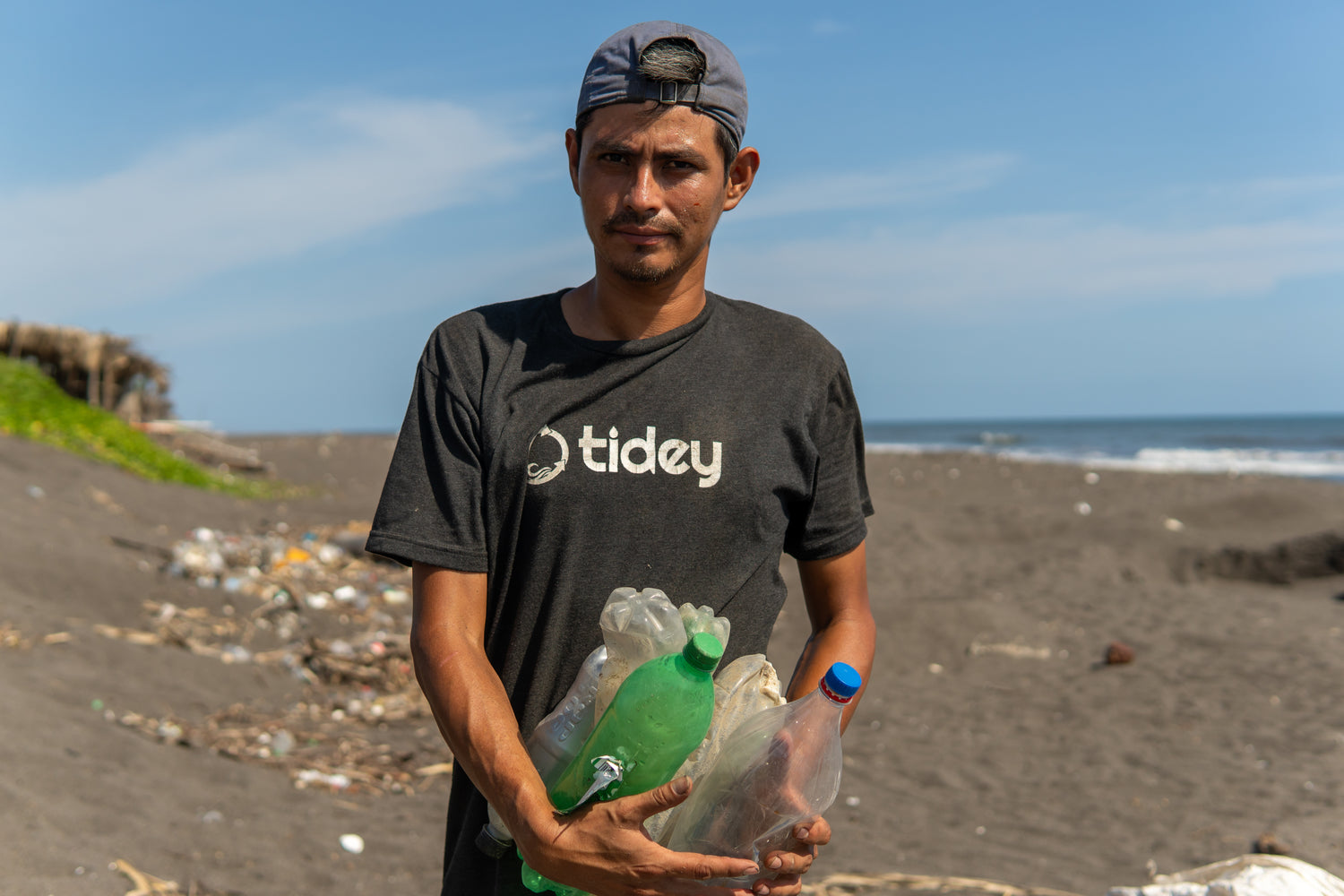 Men from Tidey Oceans picking up plastic in the water